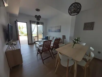 a living room with a table and chairs and a dining room at Casa deI Mar Chipiona II in Chipiona