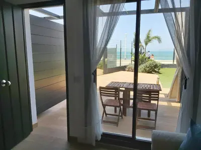 a room with a sliding glass door with a table and chairs at Casa deI Mar Chipiona II in Chipiona