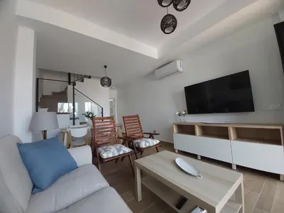 a living room with a couch and a flat screen tv at Casa deI Mar Chipiona II in Chipiona