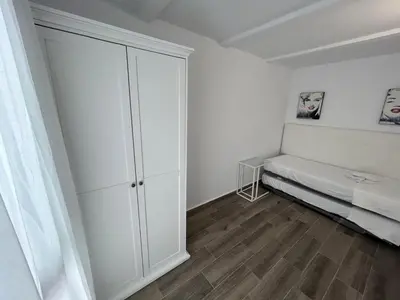 a white room with a bed and a closet at Apartamento Empul Barrosa Beach in Novo Sancti Petri