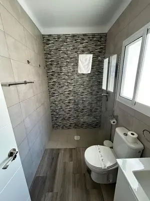 a bathroom with a white toilet and a shower at Apartamento Empul Barrosa Beach in Novo Sancti Petri