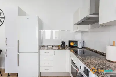 a kitchen with white cabinets and a counter top at Natural House by Livework in Cádiz