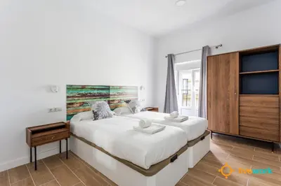 a bedroom with a large white bed and a window at Natural House by Livework in Cádiz