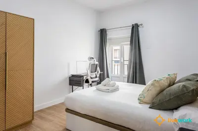 a bedroom with a bed and a desk and a chair at Natural House by Livework in Cádiz
