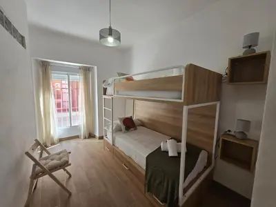 a room with two bunk beds and a chair at Allo Apartments Campana Centro 2 Habitaciones in Jerez de la Frontera