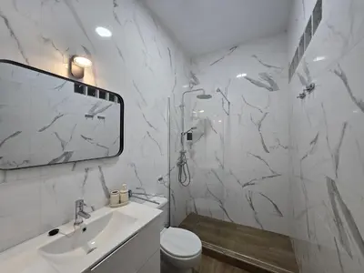 a white bathroom with a shower and a sink at Allo Apartments Campana Centro 2 Habitaciones in Jerez de la Frontera