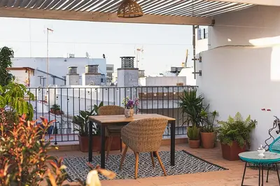 a patio with a table and chairs on a balcony at Apartamento Las 3 Terrazas in Cádiz
