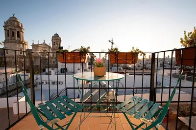 two chairs and a table on a balcony with a view of a city at Apartamento Las 3 Terrazas in Cádiz