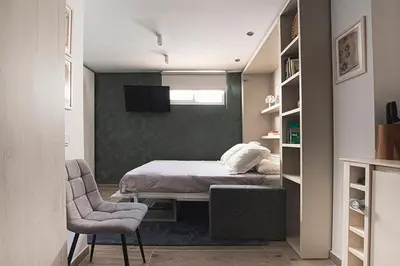 a small bedroom with a bed and a chair at Apartamento Las 3 Terrazas in Cádiz