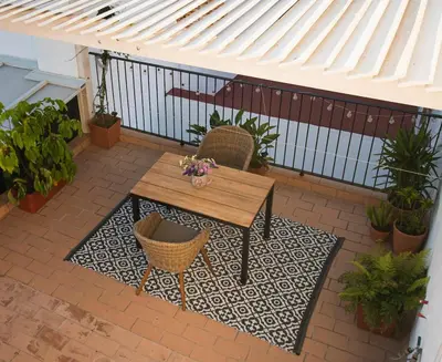 a patio with a wooden table and chairs and plants at Apartamento Las 3 Terrazas in Cádiz