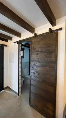 a wooden door in a bathroom with a toilet at La Cabaña del Lago in Sanlúcar de Barrameda