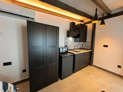 a kitchen with a black cabinet in a room at La Cabaña del Lago in Sanlúcar de Barrameda