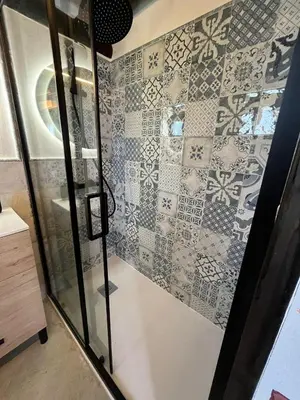 a bathroom with a shower with a tiled wall at La Cabaña del Lago in Sanlúcar de Barrameda