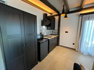 a kitchen with a black cabinet and a stove at La Cabaña del Lago in Sanlúcar de Barrameda
