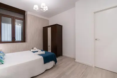 a bedroom with a large white bed and a window at CDZ - Bella in Cádiz