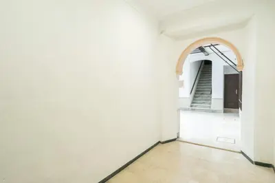 an empty hallway with an arch in a white building at CDZ - Bella in Cádiz