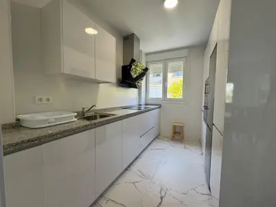 a kitchen with white cabinets and a sink and a window at Apartamento Santo Tomas Grupo AC Gestion in Cádiz