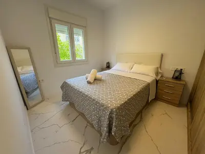 a small bedroom with a bed and a mirror at Apartamento Santo Tomas Grupo AC Gestion in Cádiz