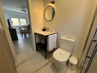 a bathroom with a toilet and a sink and a mirror at Apartamento Santo Tomas Grupo AC Gestion in Cádiz