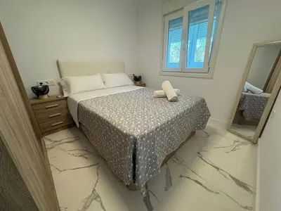 a bedroom with a bed and a mirror at Apartamento Santo Tomas Grupo AC Gestion in Cádiz