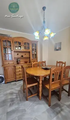 a dining room with a wooden table and chairs at Nao Santiago by Sanlúcar Housing in Sanlúcar de Barrameda