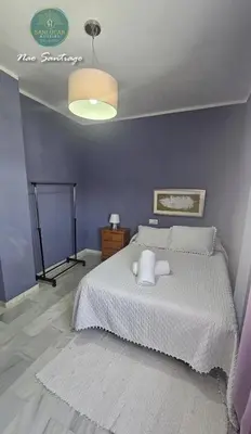a bedroom with a white bed and a blue wall at Nao Santiago by Sanlúcar Housing in Sanlúcar de Barrameda
