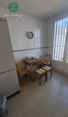 a dining room with a table and chairs and a refrigerator at Nao Santiago by Sanlúcar Housing in Sanlúcar de Barrameda