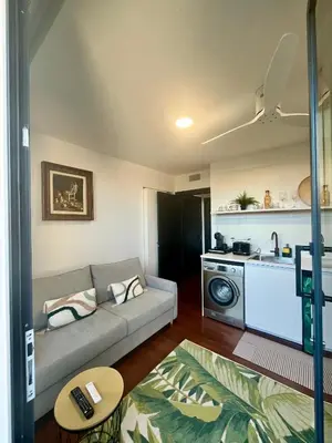 a living room with a couch and a kitchen at Puesta de Sol Doñana Adults Only in Sanlúcar de Barrameda