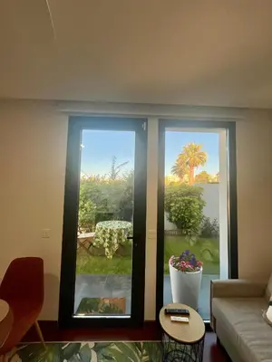 a living room with a window with a view of a garden at Puesta de Sol Doñana Adults Only in Sanlúcar de Barrameda