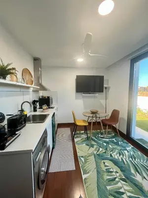 a kitchen with a sink and a table with chairs at Puesta de Sol Doñana Adults Only in Sanlúcar de Barrameda