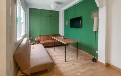 a living room with green walls and a table and a couch at Nice Home In Jerez De La Frontera in Jerez de la Frontera
