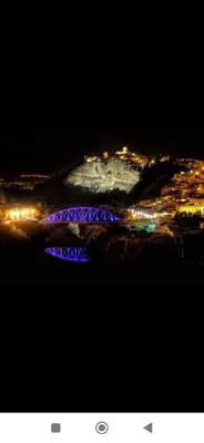 a view of a city at night with a blue bridge at El Altozano N4 in Arcos de la Frontera
