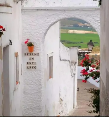 an archway in a white building with a window at El Altozano N4 in Arcos de la Frontera
