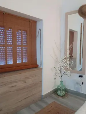 a vase with flowers in a room with a window at El Altozano N4 in Arcos de la Frontera