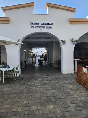 a building with an archway with people walking through it at ELEVENLIGHTS-COSTABALLENA Garden View in Costa Ballena
