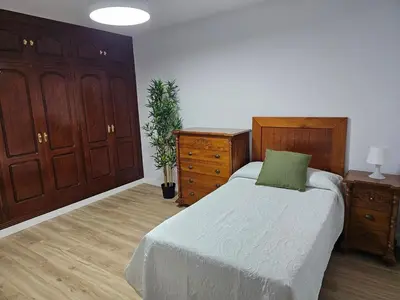 a bedroom with a bed with a green pillow on it at La Casita in Chiclana de la Frontera