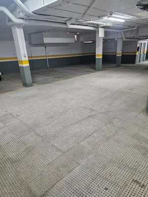 an empty parking garage with a large room with yellow and white columns at La Casita in Chiclana de la Frontera