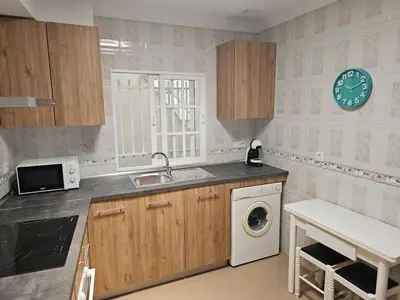 a kitchen with a sink and a washing machine at La Casita in Chiclana de la Frontera