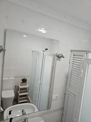 a bathroom with a sink and a mirror and a toilet at La Casita in Chiclana de la Frontera