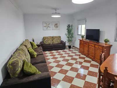 a living room with a couch and a television at La Casita in Chiclana de la Frontera