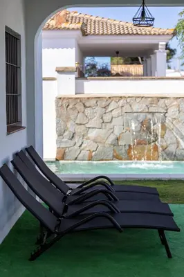 a black chair sitting next to a house at Montijo Relax and Sunny Private Pool in Cádiz
