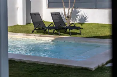 two chairs sitting next to a swimming pool at Montijo Relax and Sunny Private Pool in Cádiz