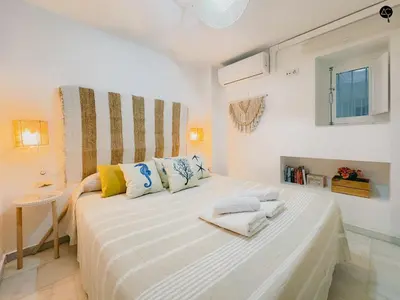 a bedroom with a large white bed with towels on it at Viña Coqueta Grupo AC Gestion in Cádiz