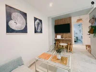 a living room with a glass table and a tv at Viña Coqueta Grupo AC Gestion in Cádiz