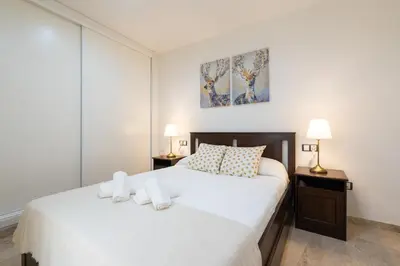 a white bedroom with two beds and two lamps at CDZ - Cristóbal Colón in Cádiz