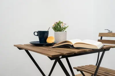 a table with an open book and a cup of coffee and a book at CDZ - Cristóbal Colón in Cádiz
