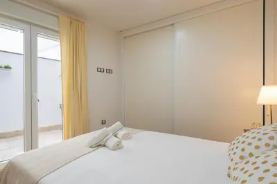 a bedroom with a white bed with a large window at CDZ - Cristóbal Colón in Cádiz