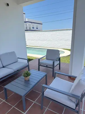 a patio with two chairs and a couch and a table at Casita de Mar in Conil de la Frontera