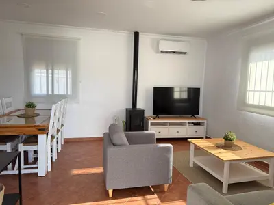 a living room with a tv and a table and a couch at Casita de Mar in Conil de la Frontera