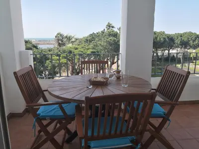 a wooden table and chairs on a balcony at Casa Ensenada by 7Escalones in Rota
